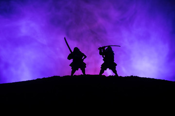 Silhouette of two samurais in duel. Picture with two samurais and sunset sky