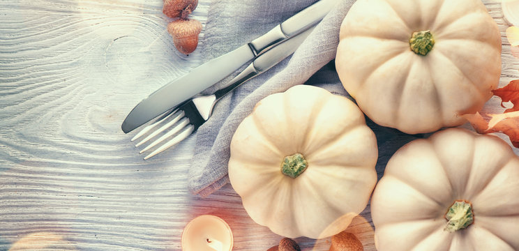 Thanksgiving background. Holiday scene. Wooden table, decorated with pumpkins, autumn leaves and candles. Flatlay. Top view