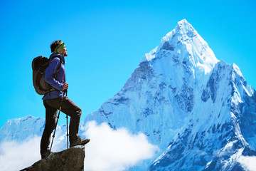 Hiker with backpacks reaches the summit of mountain peak. Success, freedom and happiness, achievement in mountains. Active sport concept.
