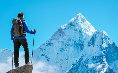 Hiker with backpacks reaches the summit of mountain peak. Success, freedom and happiness,...