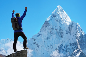 Hiker with backpacks reaches the summit of mountain peak. Success freedom and happiness achievement...
