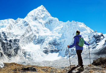 Hiker with backpacks reaches the summit of mountain peak. Success, freedom and happiness, achievement in mountains. Active sport concept.