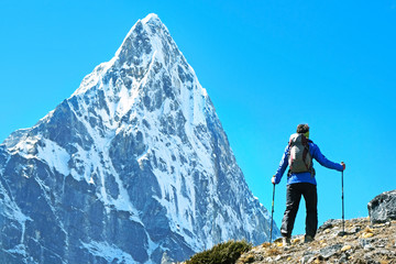 Hiker with backpacks reaches the summit of mountain peak. Success, freedom and happiness, achievement in mountains. Active sport concept.