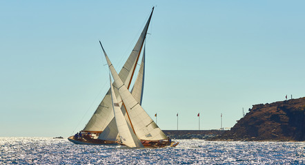 Sailboat under white sails at the regatta. Sailing yacht race.