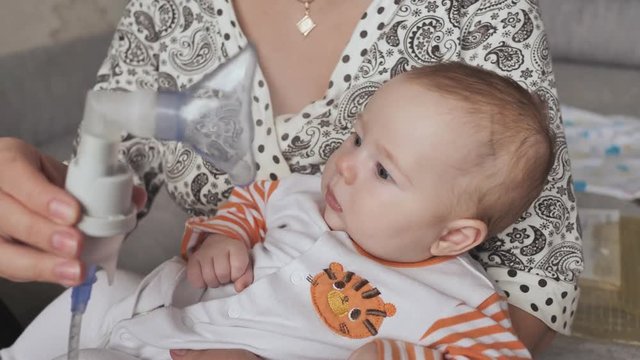 Infant getting breathing treatment from mother while suffering from illness.