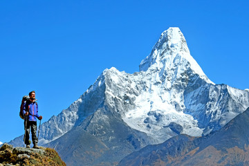 Hiker with backpacks reaches the summit of mountain peak. Success, freedom and happiness, achievement in mountains. Active sport concept.