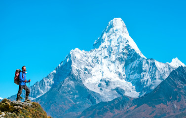 Tourist with backpack enjoys Ama Dablam view on a trek to Everest Base Camp. Success, freedom and...