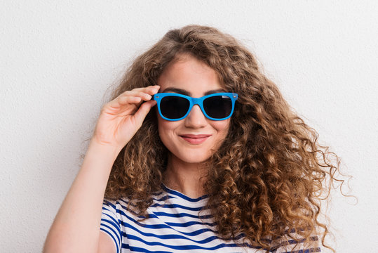 Young beautiful cheerful woman with sunglasses in studio.