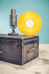 Retro classic studio microphone from 50s and gold vinyl disc record circa 70s on old aged classic...
