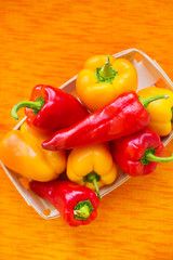 yellow and red peppers closeup on orange napkin.