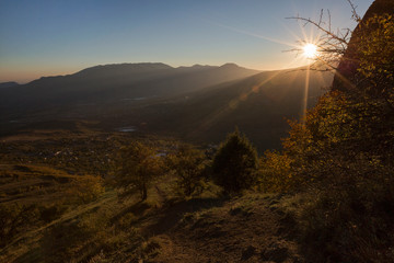 Beautiful view of the valley in the sun rays in the mountains Demerdzhi and yellow trees in the autumn Crimea