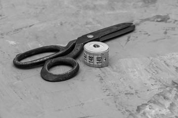 vintage  big old scissors and tailor centimeter on gray background