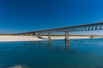 Fototapeta na wymiar New Zealand's longest one-lane bridge over Haast River, South Westland