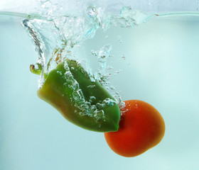 Vegetables tomato and papper in water splash on blue