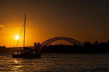 Sunset on Sydney Harbour. Sailing on a catamaran with the Sydney Harbour Bridge in the background.