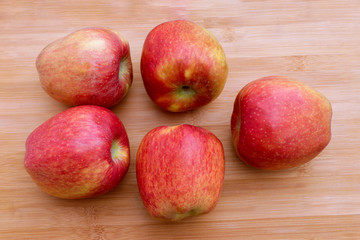 Group of red apples on wooden surface