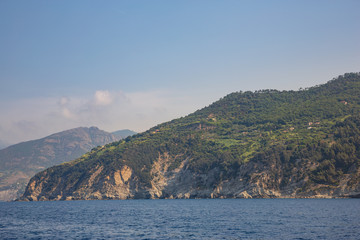 Fototapeta na wymiar The rugged coastline of the Ligurian coast, with several houses perched on top of the cliffs outside Monterosso al Mare, Italy