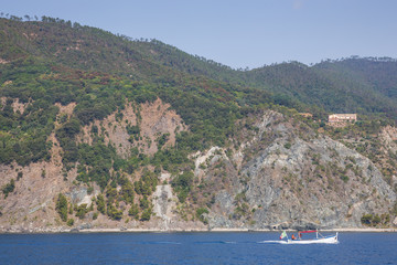 Fototapeta premium Private boat heading back into harbour ast Monterosso al Mare, Cinque Terre, Italy