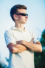portrait of a sporty young man in sun glasses, on nature