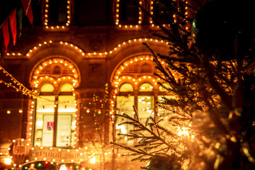Naklejka premium Christmas fair in the square. Garlands, flags and lights. Evening.
