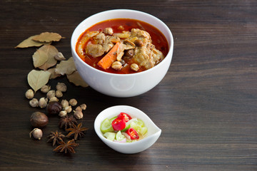 Chicken massaman curry with herb on wooden background, coconut milk curry, Thai local food