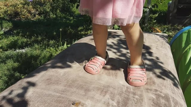 little girl jumping on a trampoline, feet close-up.
