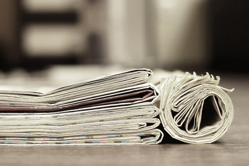 Close up texture of folded and rolled newspapers on wooden table, retro news background