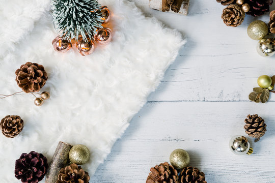 Christmas tree with golden baubles and pine cones on a white background. Cozy winter flat lay image.