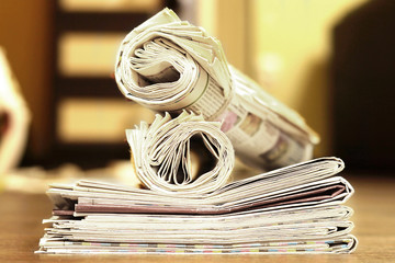 Newspapers folded and rolled in vintage style, side view