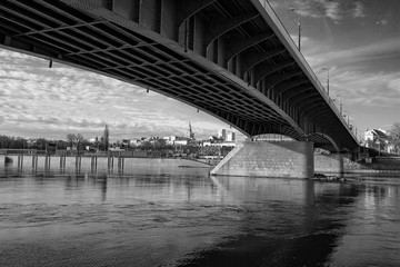 Fototapeta na wymiar Warsaw - a bridge over the Vistula river with a panorama of the coastal city - photo in black and white