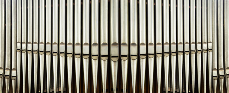 part of the church organ with many air pipes made of metal
