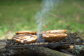 Laying buns on a metal grill, roasted with fire and smoke