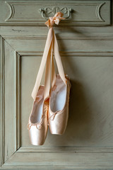 Pink pointes with ribbons and flowers. Spring ballet shoes with roses on the background. Vintage...
