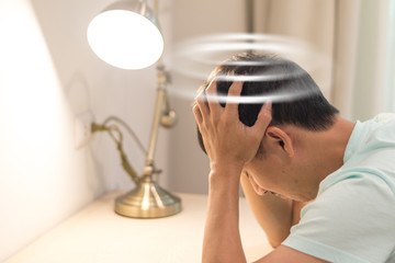 Vertigo illness concept. Man hands on his head felling headache dizzy sense of spinning dizziness,a...