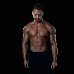 Fototapeta na wymiar Brutal strong bodybuilder athletic man posing on black background.
