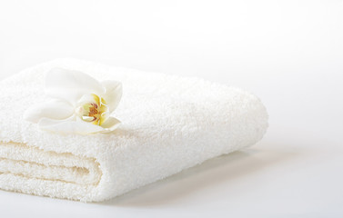 Obraz na płótnie Canvas White Spa towel with Orchid flower on white background