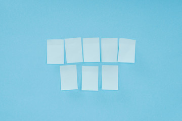 eight blank sticky notes isolated on blue background