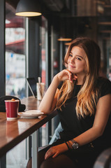 Beautiful shy women in simple minimal design cafe with coffee cup