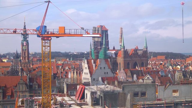 Aerial view at construction cranes and Gdansk oldtown panorama in 4k slow motion 60fps