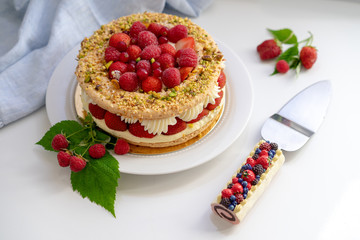 Delicious home made cake with fresh strawberries and rasberries on the white background. Isolated