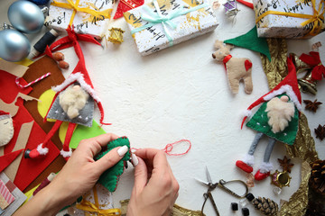 woman sews New Year's felt toys.Top view