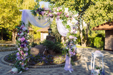 Wedding day, ceremony place for the bride and groom, decor, flowers. Concept of decor, wedding arch is decorated with flowers - pink and white peonies.