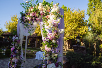 Wedding day, ceremony place for the bride and groom, decor, flowers. Concept of decor, wedding arch is decorated with flowers - pink and white peonies.