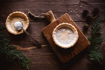 Weihnachtliches Mürbeteig Tartelette auf dunklem Holz und Tannen Dekoration
