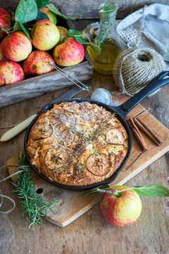Apple pie baked in a frying pan with olive oil and rosemary