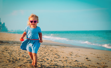 happy cute little girl run play on beach