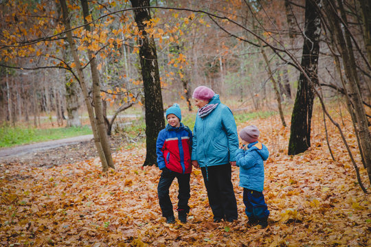 grandmother with kids walk in autumn fall nature
