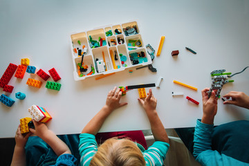 kids play with plastic blocks, building robot at school lesson