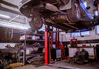 The car in a car service is lifted on a jack for repair