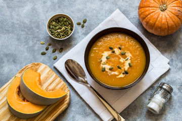 pumpkin soup with pumpkin seeds and cream on a light background